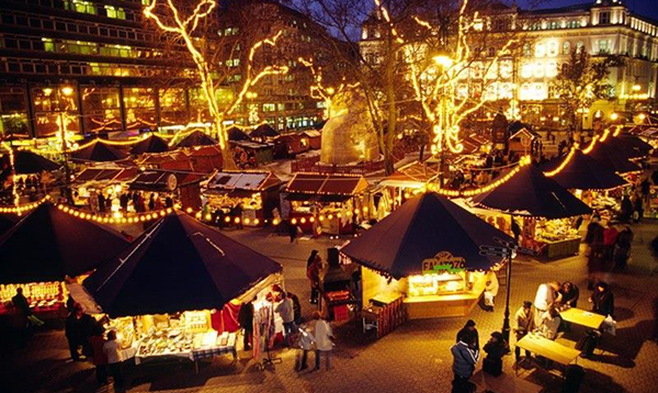 Adventný zájazd do Budapešti zachytáva nočnú atmosféru vianočných trhov s mnohými osvetlenými stánkami a návštevníkmi.