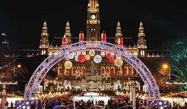 Adventný zájazd do Viedne predstavuje slávnostné vianočné trhy pred Viedenskou radnicou s veľkým osvetleným oblúkom.