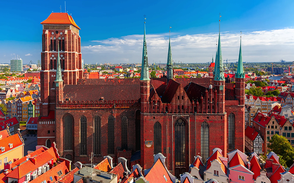 Bazilika Nanebovzatia Panny Márie v Gdansku týčiaca sa nad strechami starého mesta
