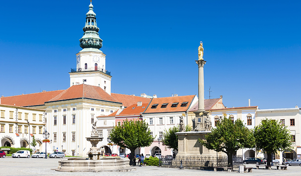 Slnečné historické centrum mesta Kroměříž s dominantnou vežou, morovým stĺpom a malebnými budovami na rozľahlom námestí láka turistov na príjemnú prechádzku.