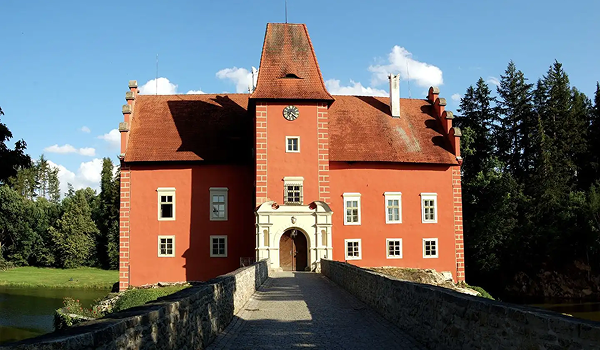 Ikonický renesančný vodný zámok Červená Lhota v južných Čechách s prístupovým kamenným mostom.
