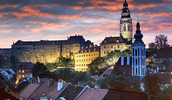 Podvečerná panoráma historického centra s dominantným komplexom hradu a zámku Český Krumlov.