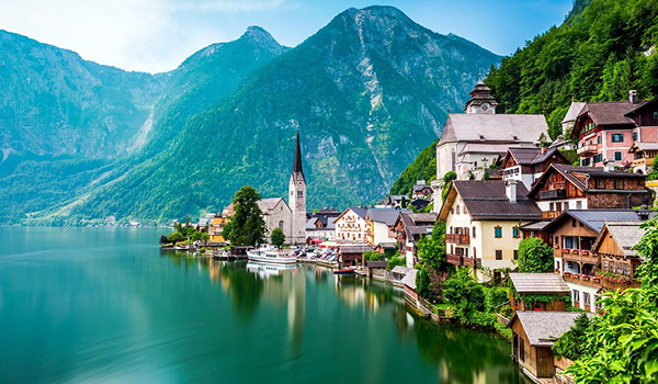 Ikonický pohľad na rakúsky Hallstatt s kostolnou vežou na brehu jazera pod úpätím vysokých Álp.