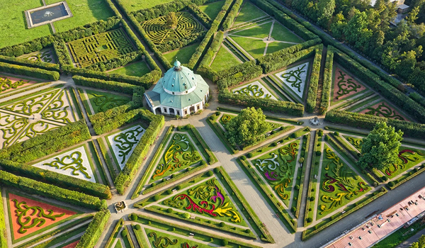 Letecký pohľad na symetrické zelené bludiská a elegantný centrálny pavilón ukazuje nádhernú Květnú záhradu v Kroměříži, ktorá je pamiatkou UNESCO.