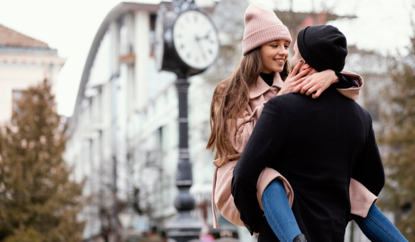 Muž drží ženu na rukách a sú spolu na romantickom výlete.